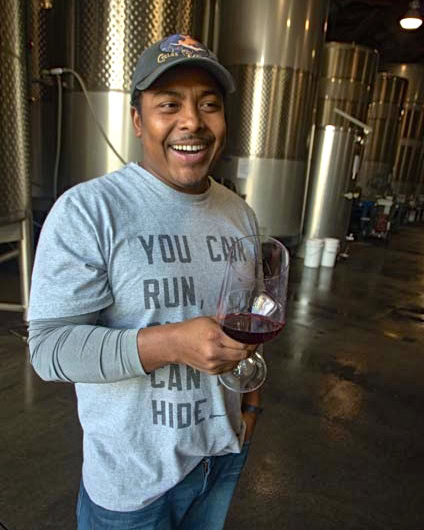 Man enjoying wine tasting at Lodi Winegrape Commission winery with wine glass in hand.