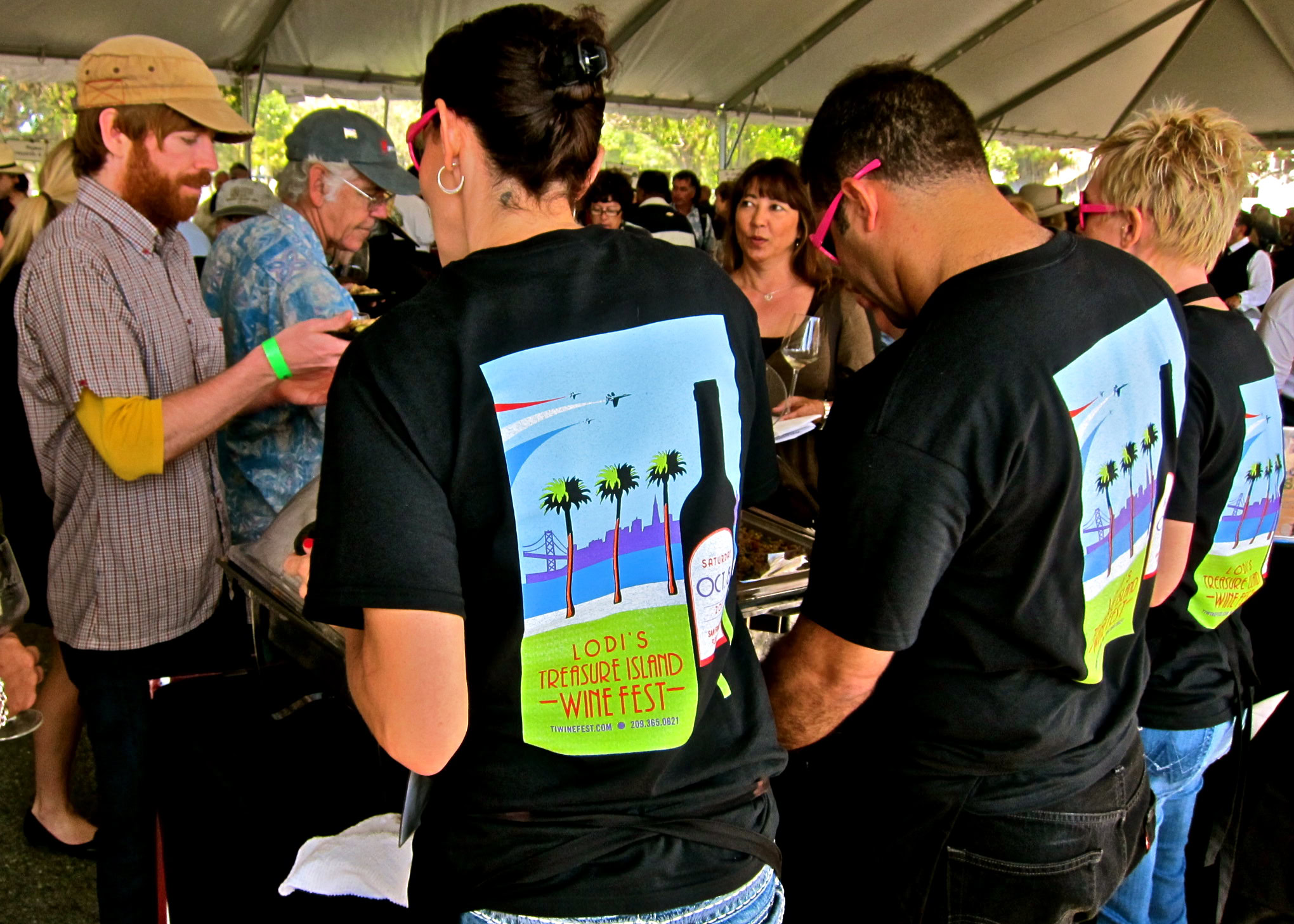 People at Lodi Winegrape Commission event wearing event T-shirts under a tent.