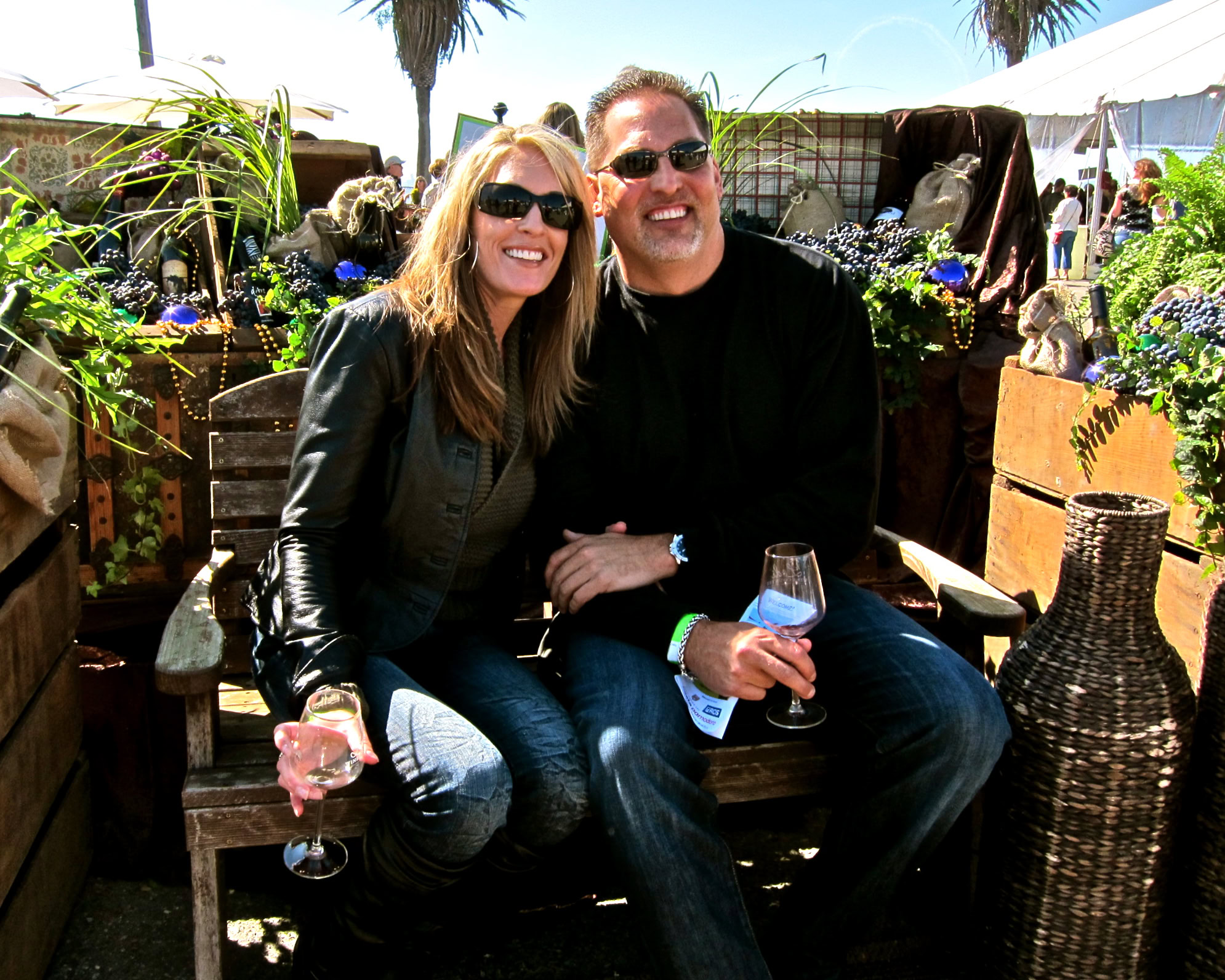 Smiling couple enjoying wine at Lodi Winegrape Commission outdoor event.