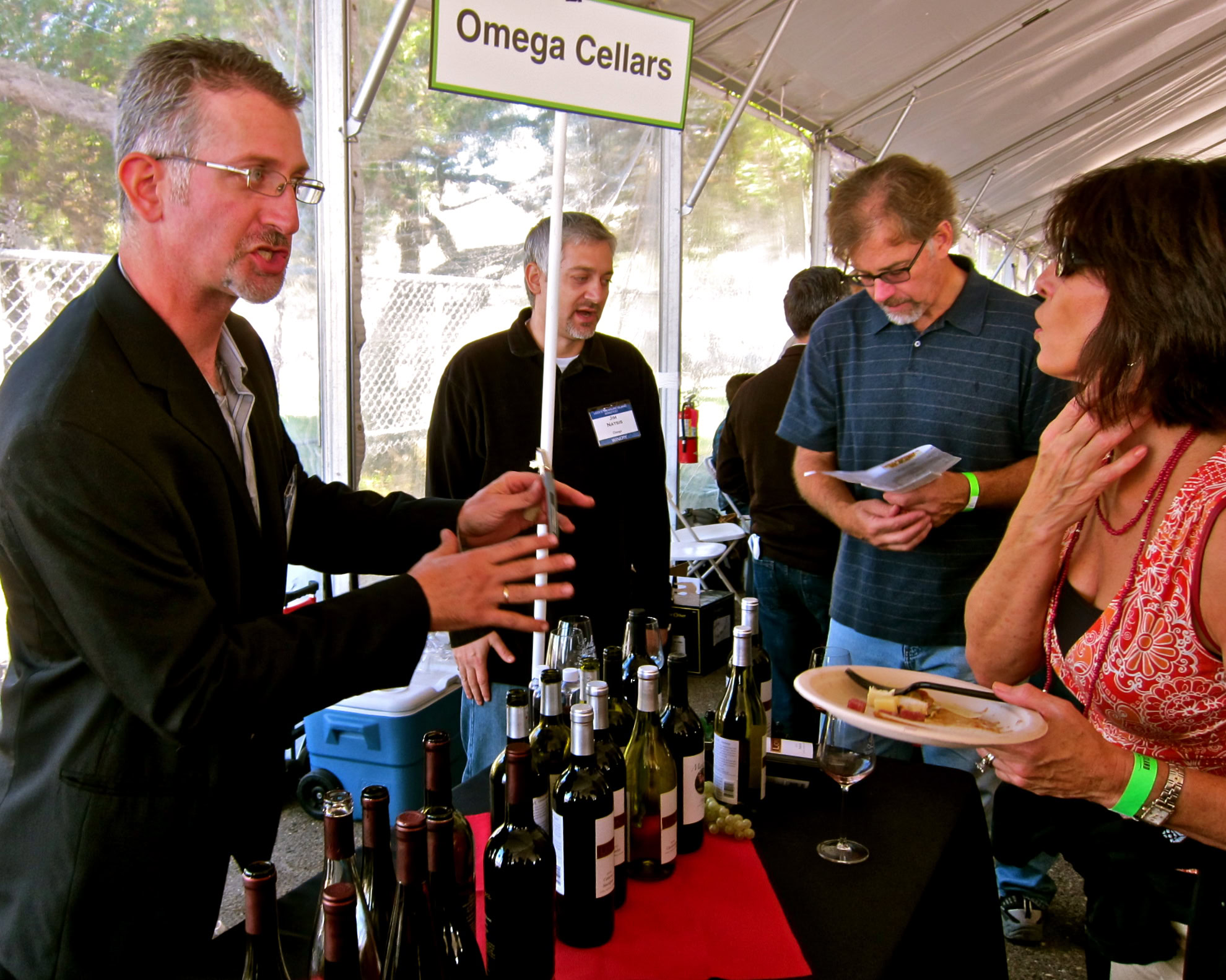 Wine tasting at Lodi Winegrape Commission booth with attendees and wines on display.
