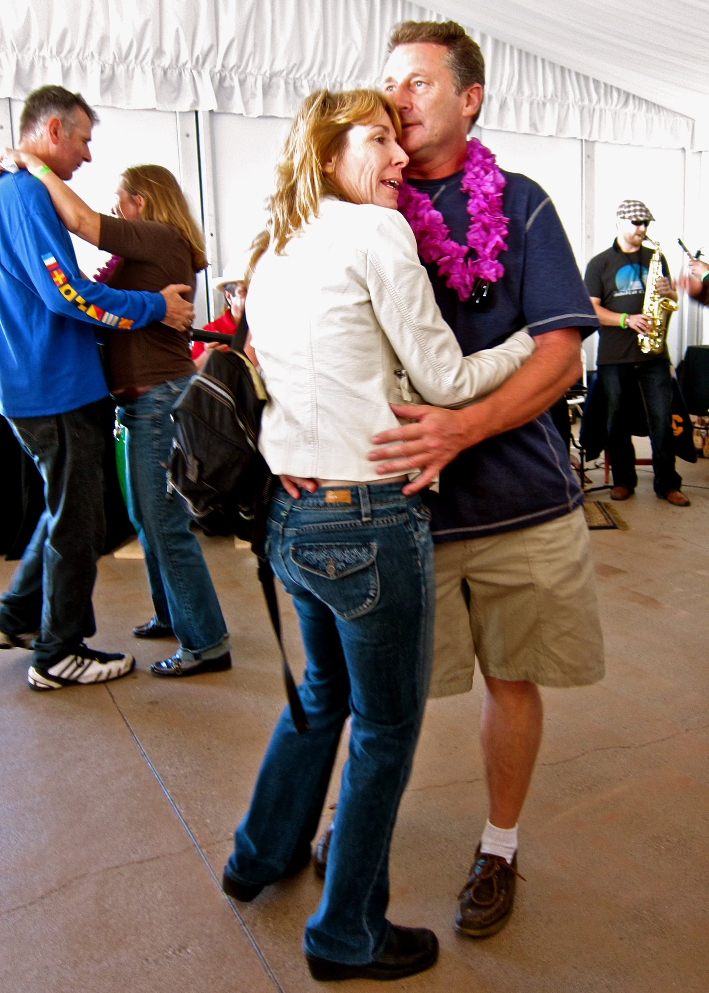 Couple dancing at Lodi Winegrape Commission event with friends in background.