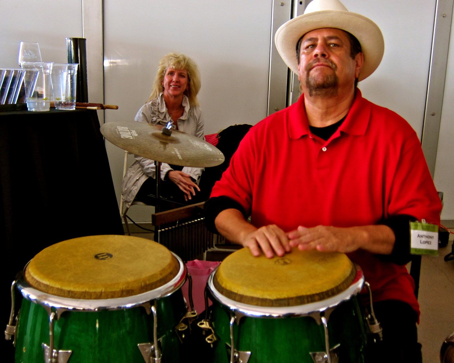 Musicians performing at a Lodi Winegrape Commission event, featuring a man with a cowboy hat playing conga drums and a woman.