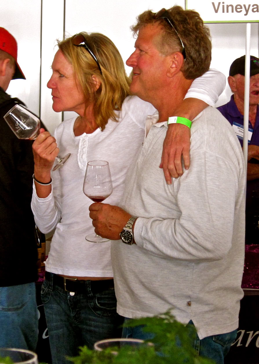 Couple enjoying wine tasting at Lodi Winegrape Commission event, holding wine glasses and engaging in conversation.