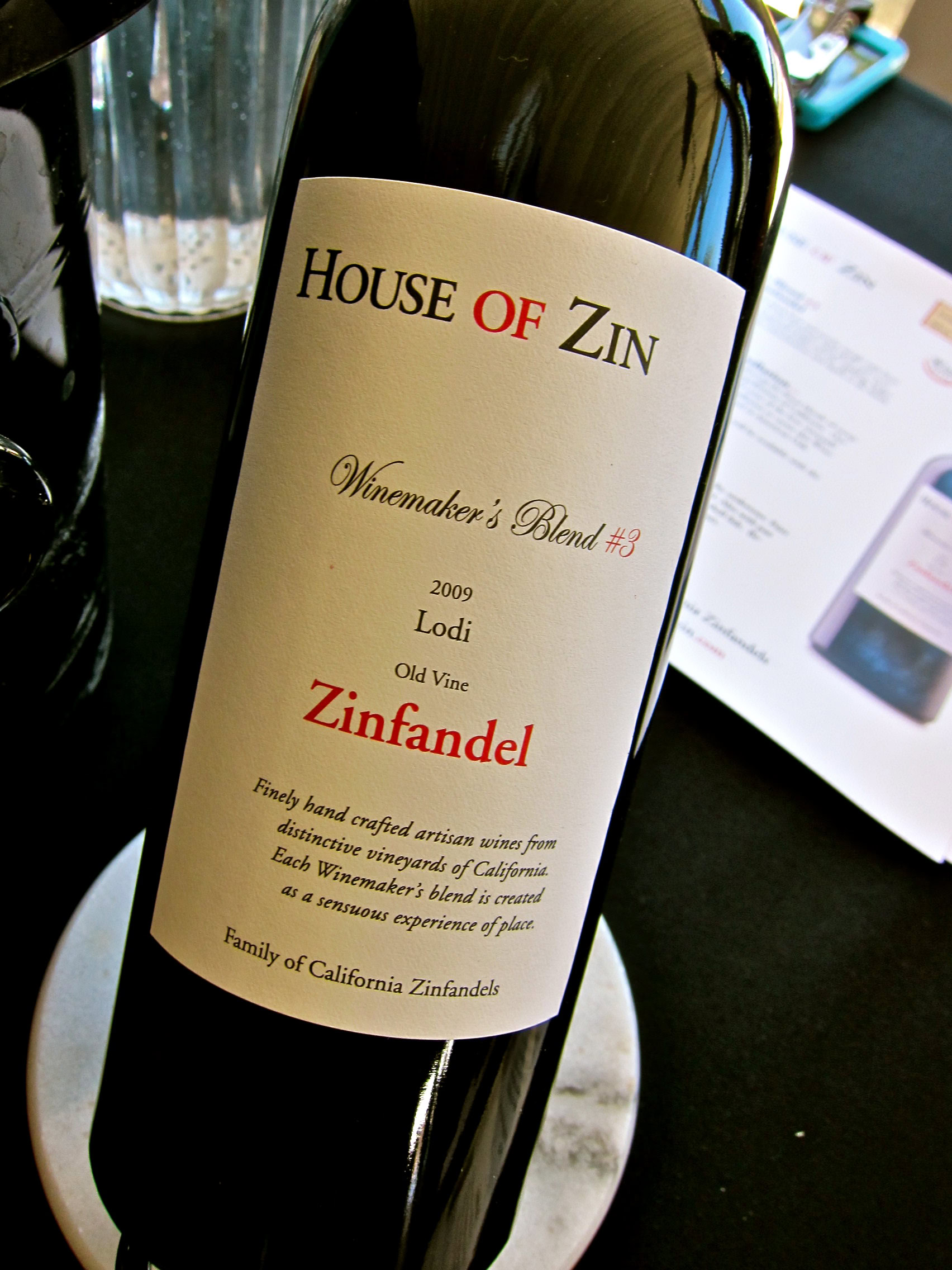 Bottle of House of Zin Zinfandel wine from Lodi, California, with a white label and black and red text.