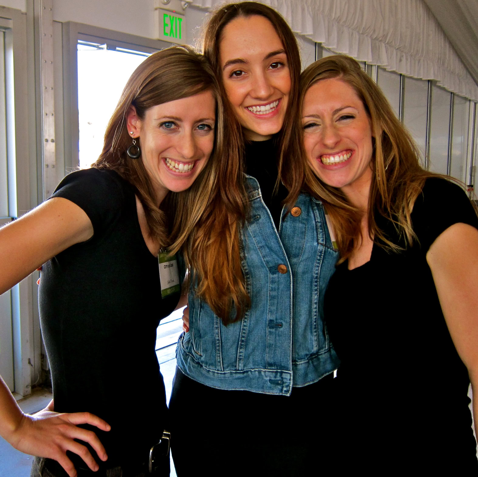 Three smiling women at Lodi Winegrape Commission event, enjoying wine and networking.