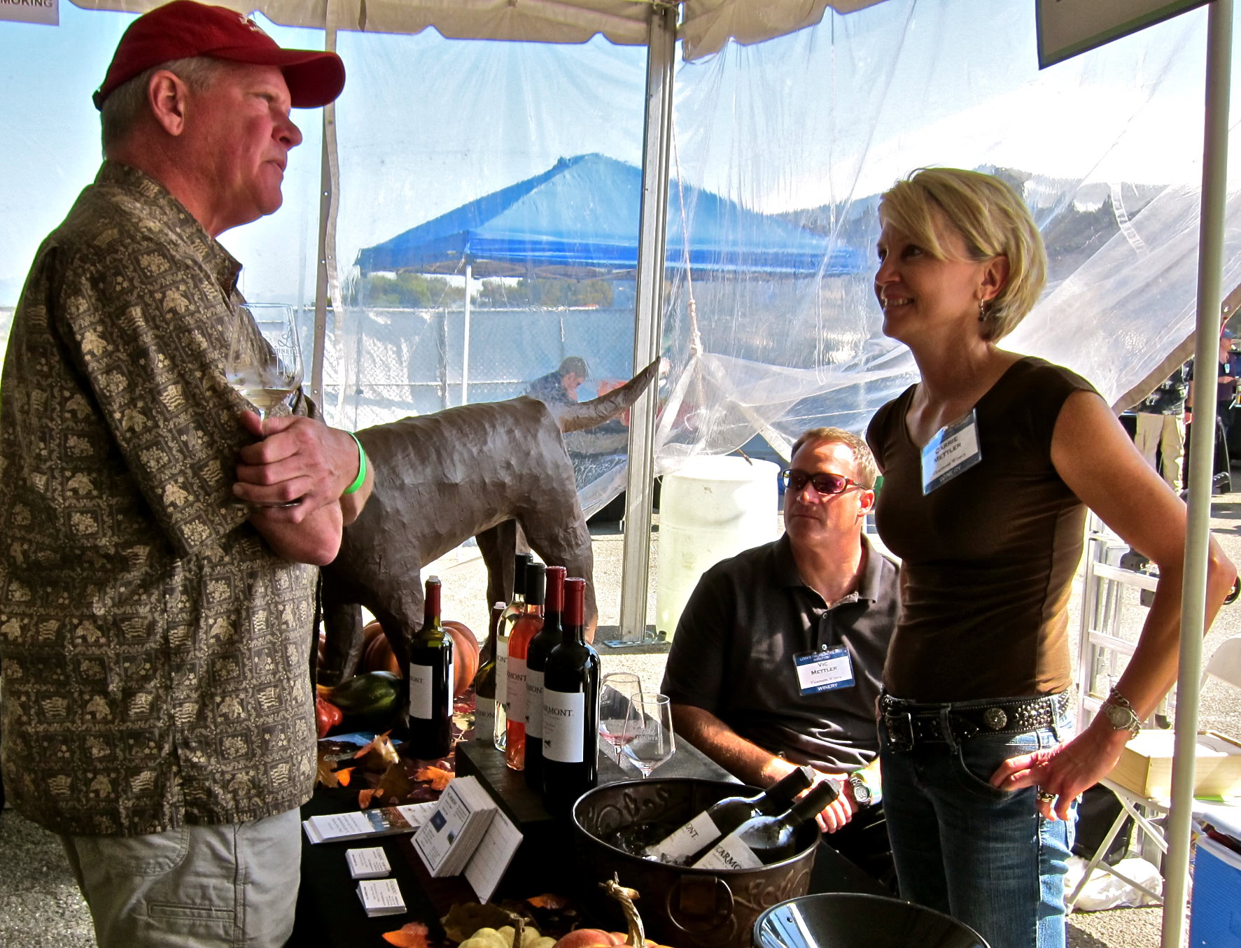 Lodi Winegrape Commission booth at a wine event with people tasting and discussing wines.