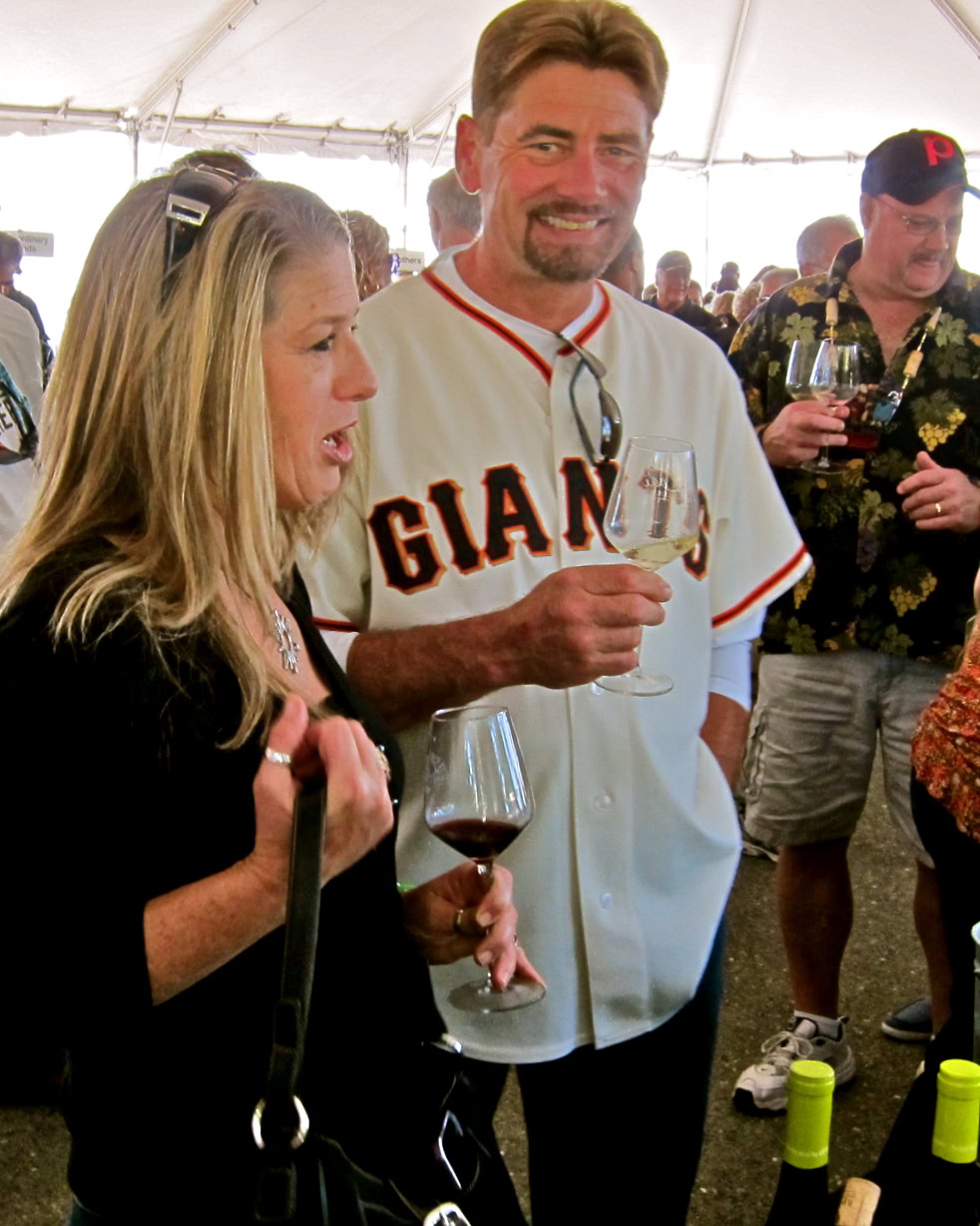People enjoying wine tasting at a Lodi Winegrape Commission event under a tent.
