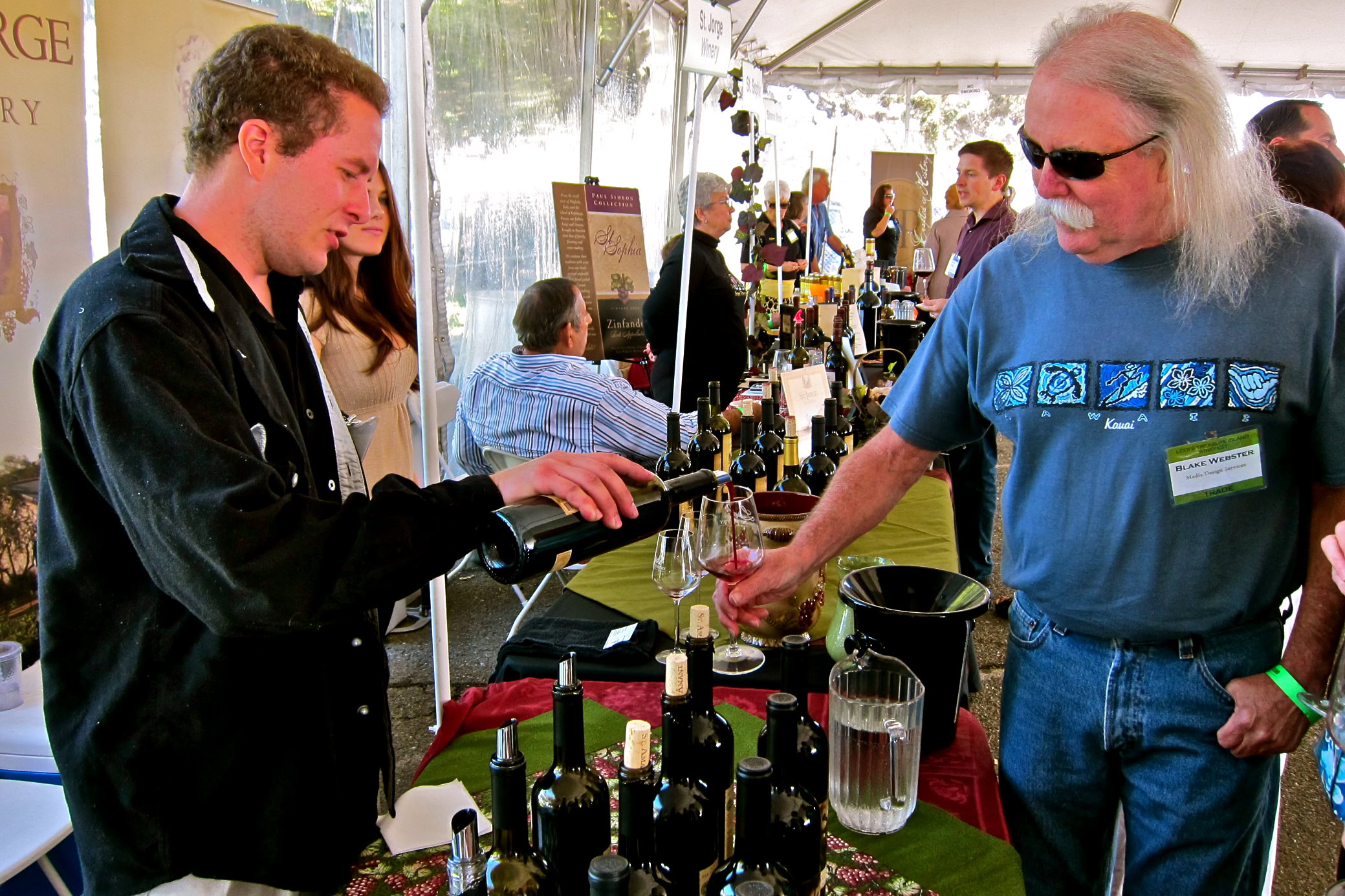 Wine tasting at Lodi Winegrape Commission event with bottles and glasses on display.