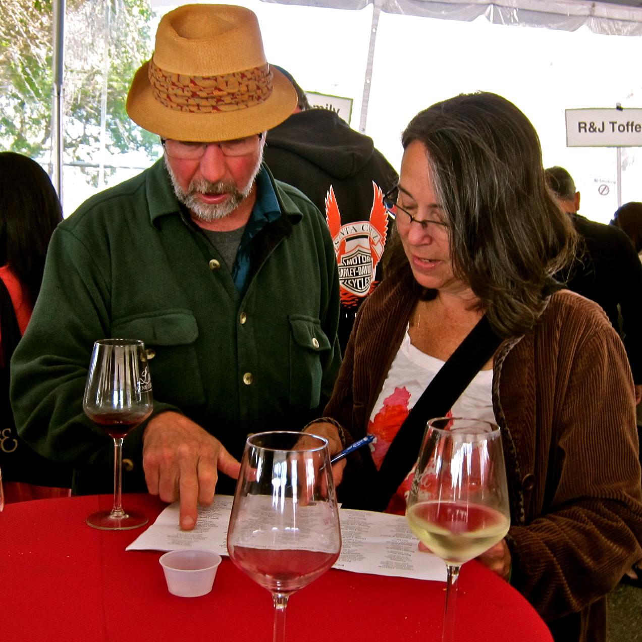Two people tasting wine at a Lodi Winegrape Commission event, discussing wine notes and flavors.