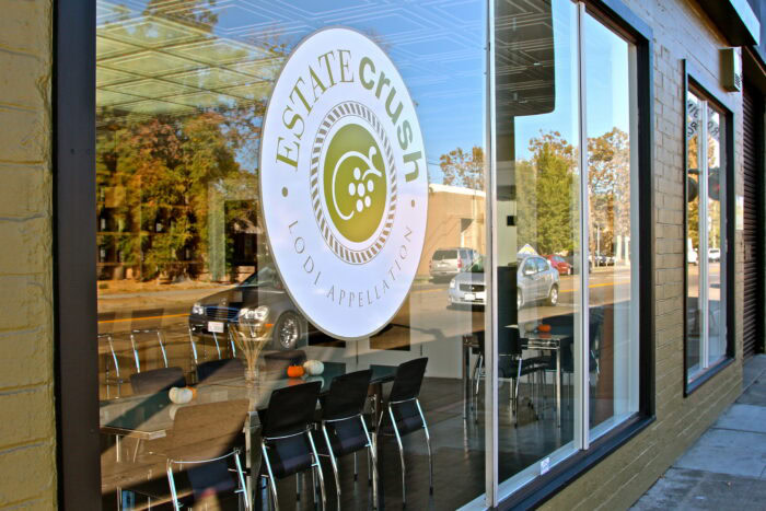 Exterior view of Lodi Winegrape Commission office with logo on glass window, showcasing local wine industry.