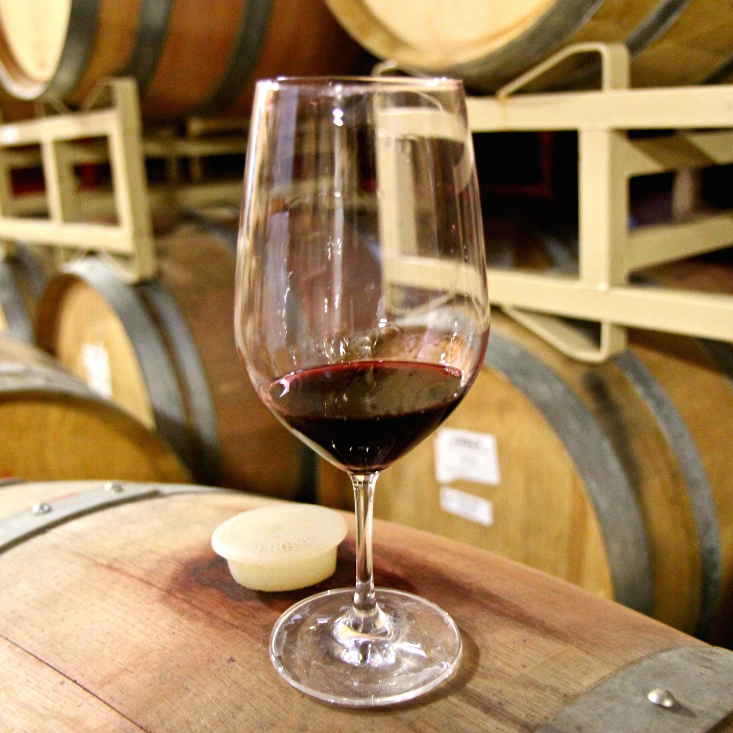 Glass of red wine on a wooden barrel at Lodi Winegrape Commission event.