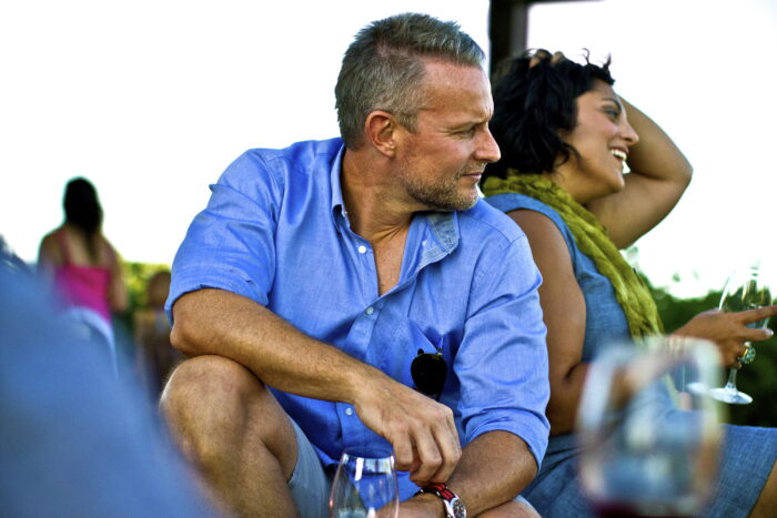 Smiling man and woman enjoying outdoor wine tasting at Lodi Winegrape Commission event.