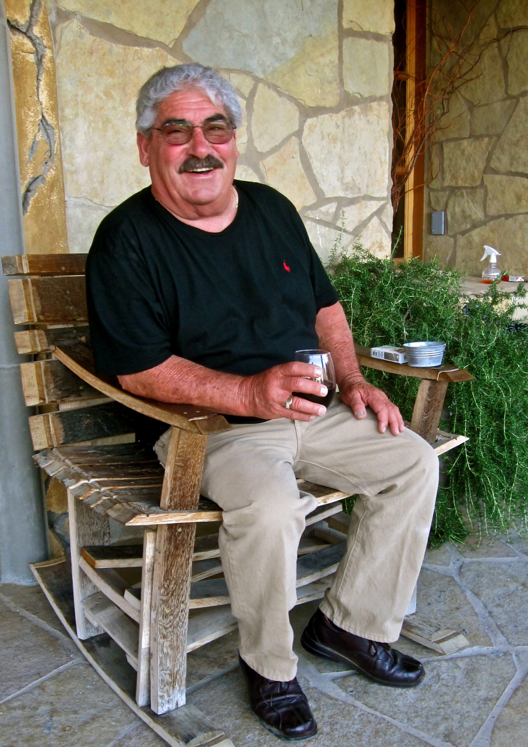Smiling man enjoying wine outdoors at Lodi Winegrape Commission event.