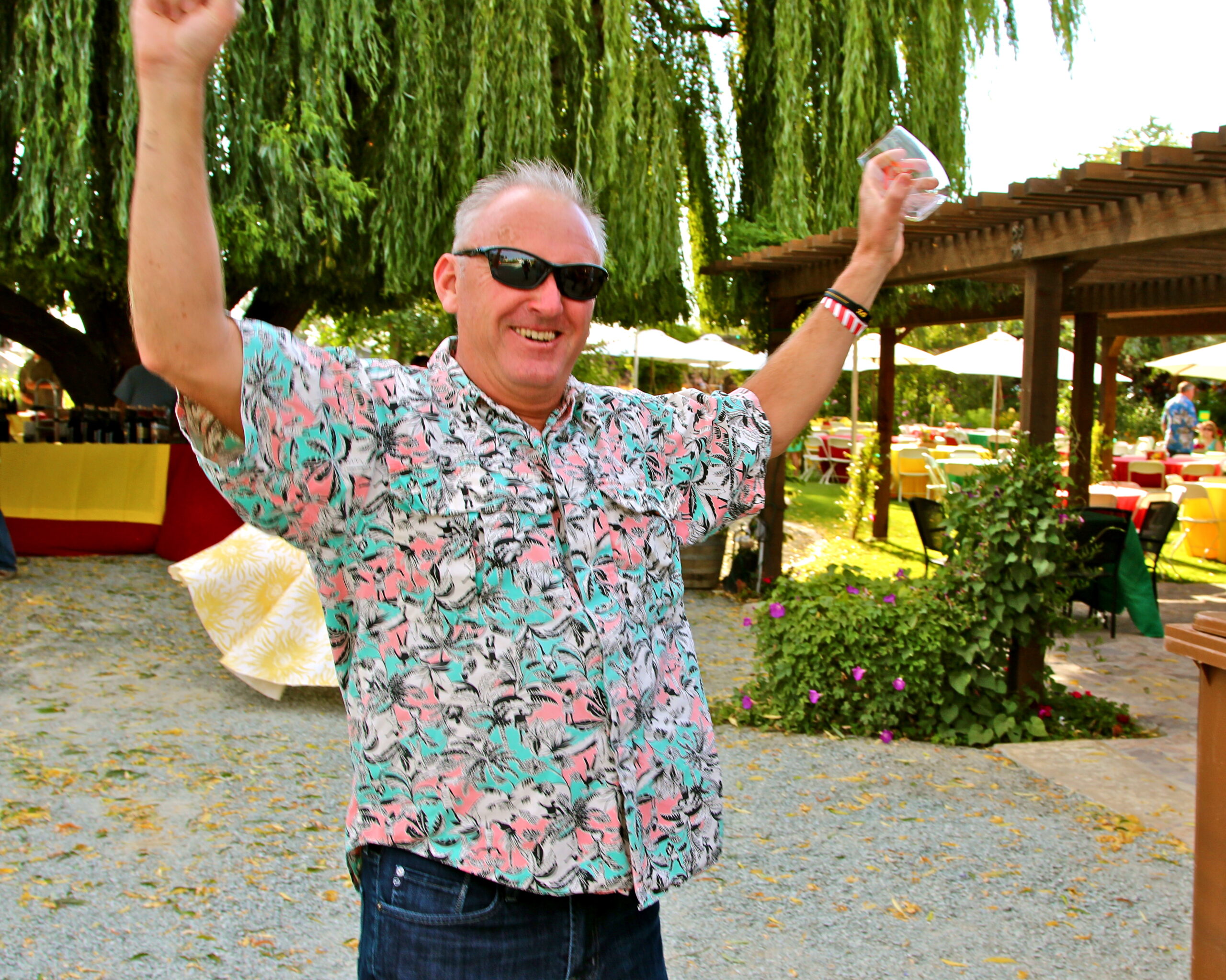 Smiling man in floral shirt celebrating outdoors at Lodi Winegrape Commission event.