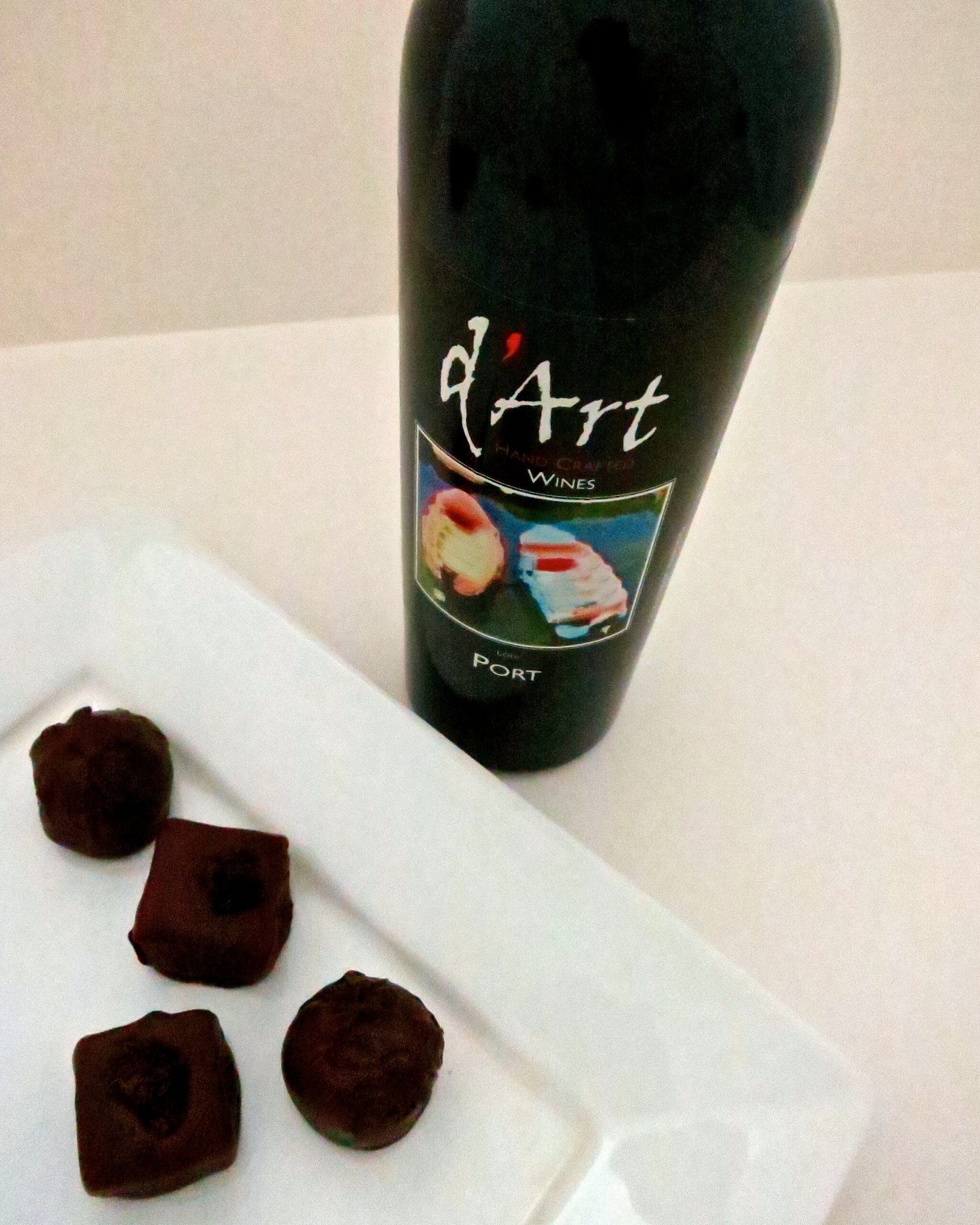 Lodi Winegrape Commission wine bottle with chocolates on a white surface.