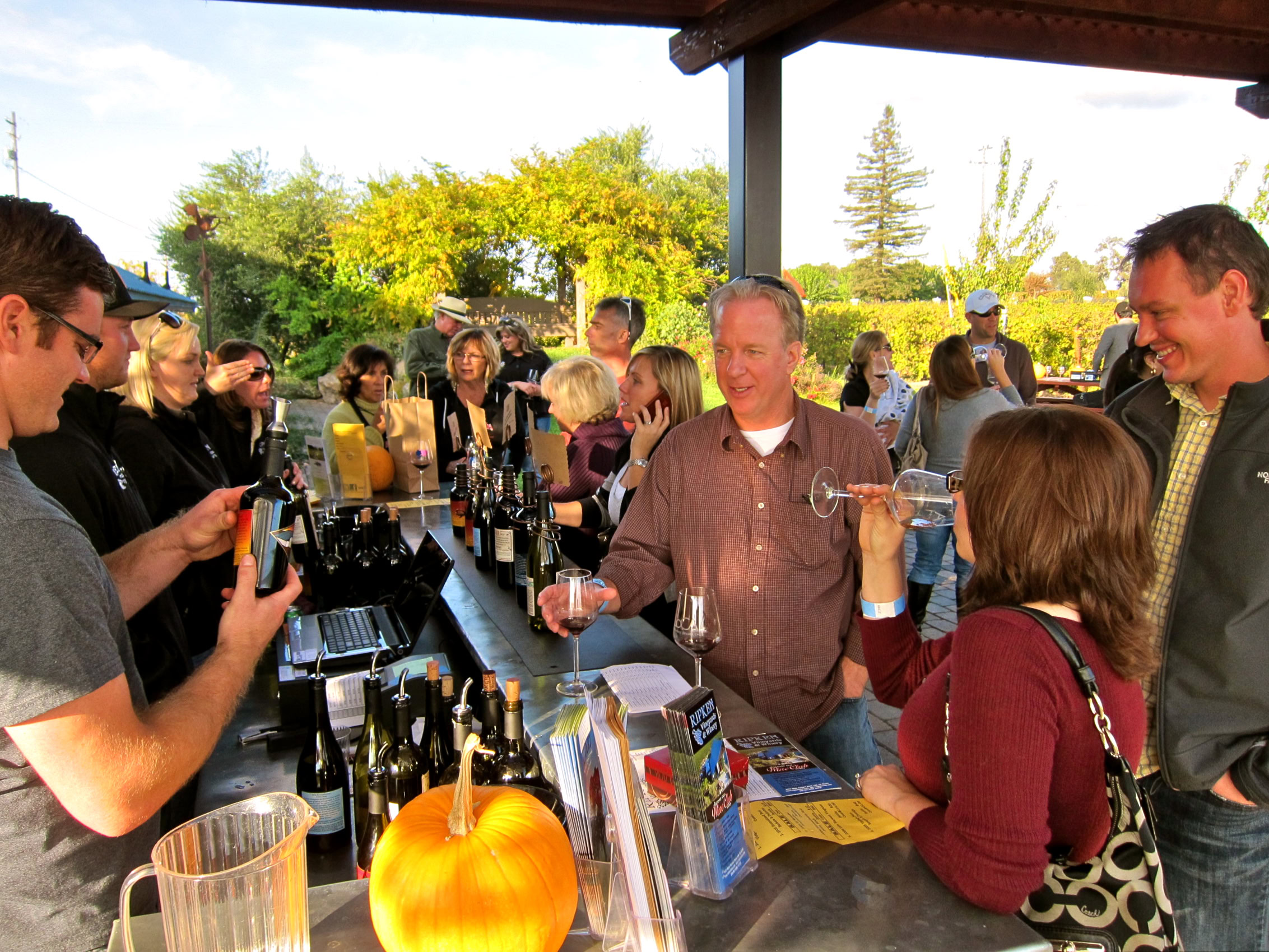 People enjoying wine tasting at a Lodi Winegrape Commission event outdoors.