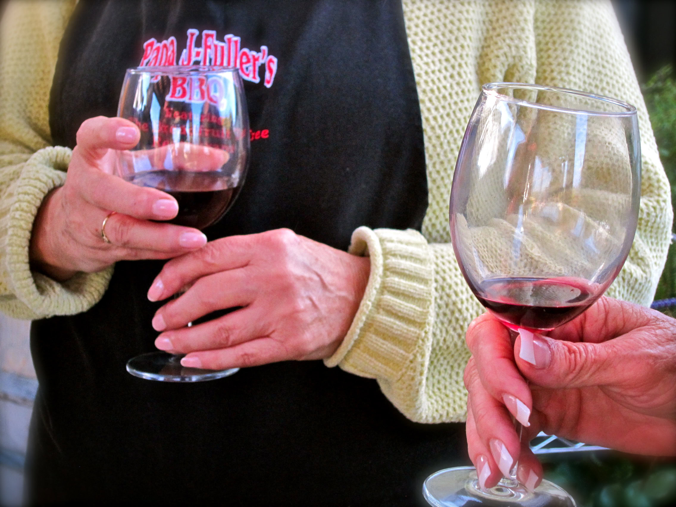 People tasting red wine from glasses at a wine event, showcasing Lodi's wine culture.