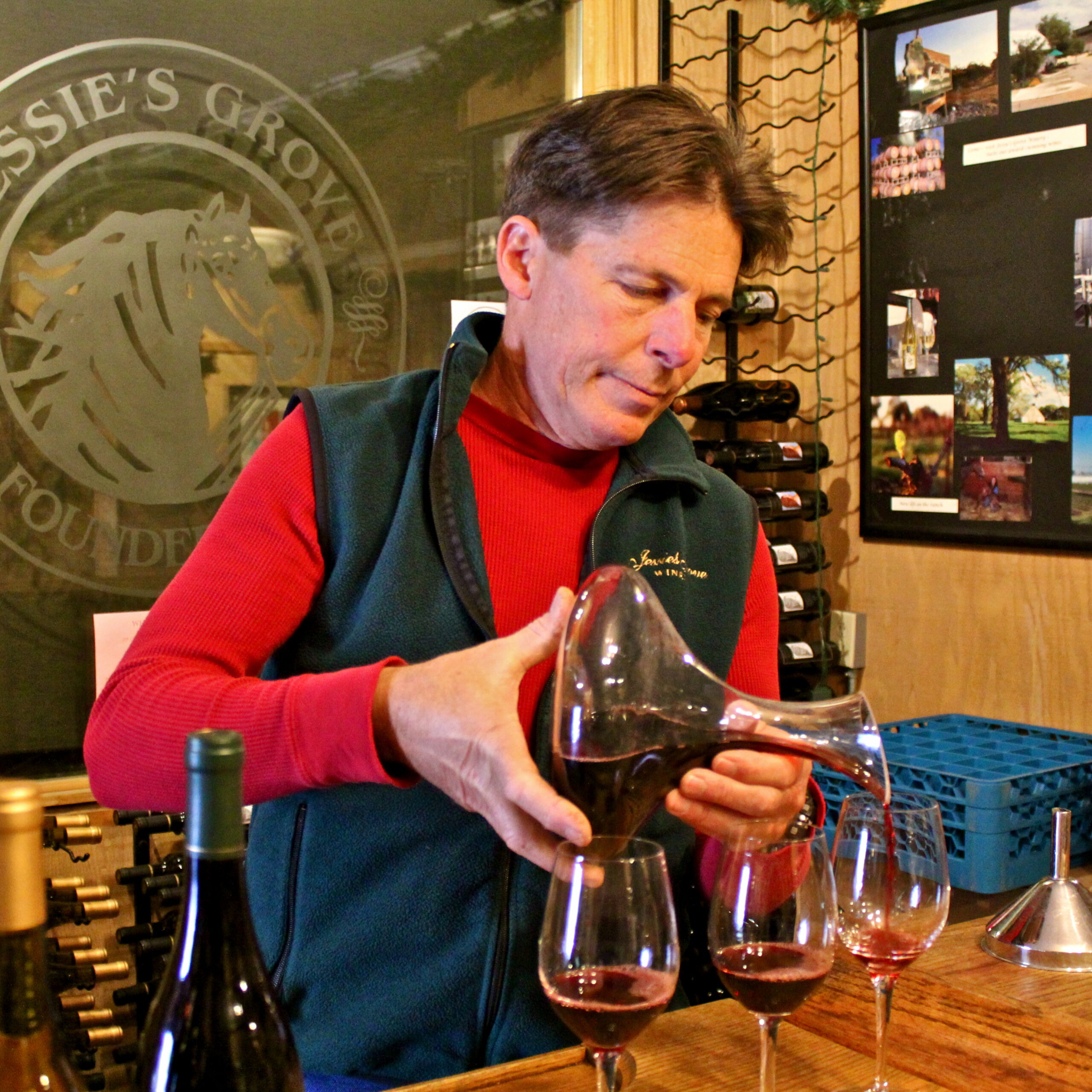 Man pouring red wine into glasses at Lodi Winegrape Commission tasting event.