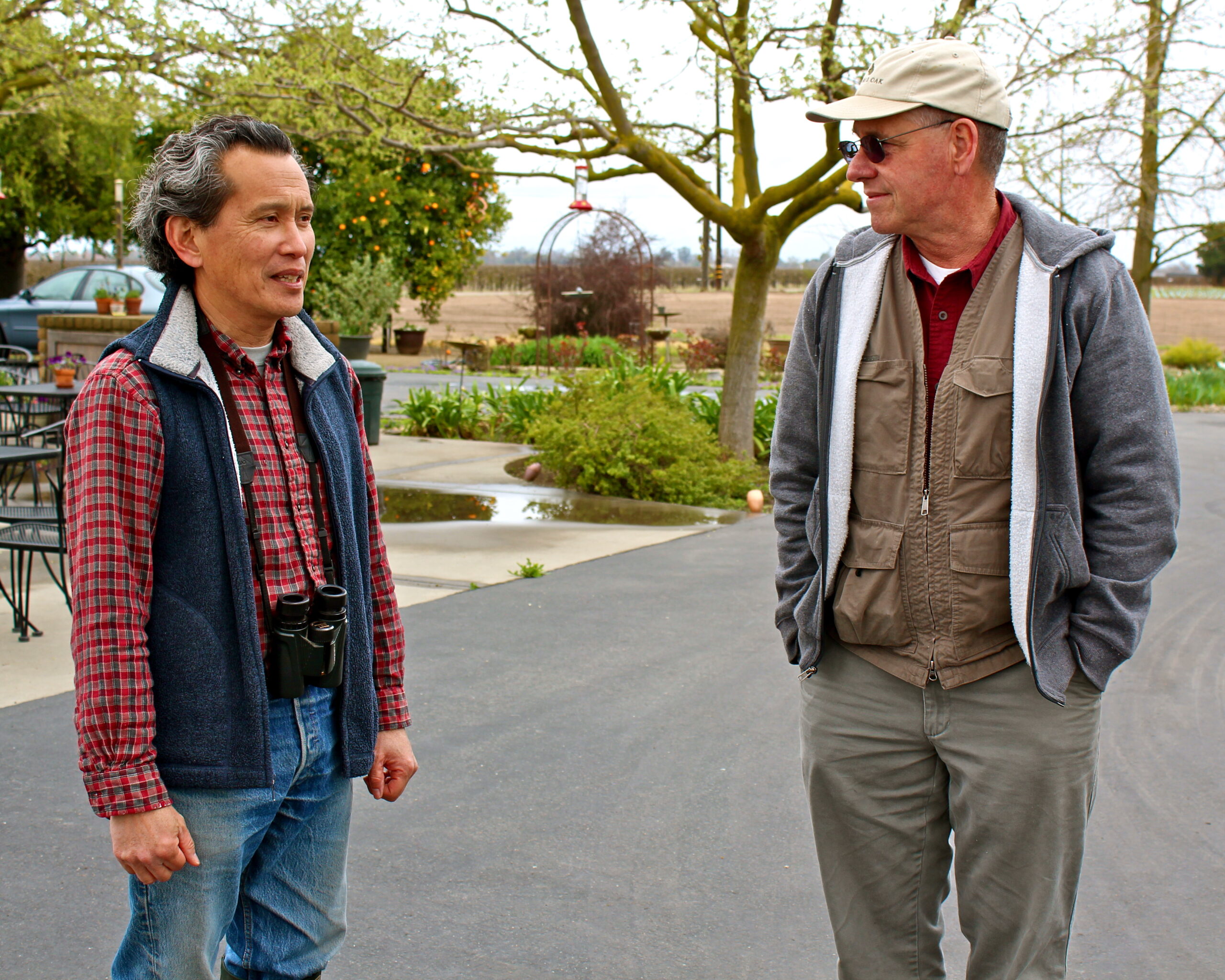Two men talking outdoors at a vineyard, representing Lodi Winegrape Commission activities.
