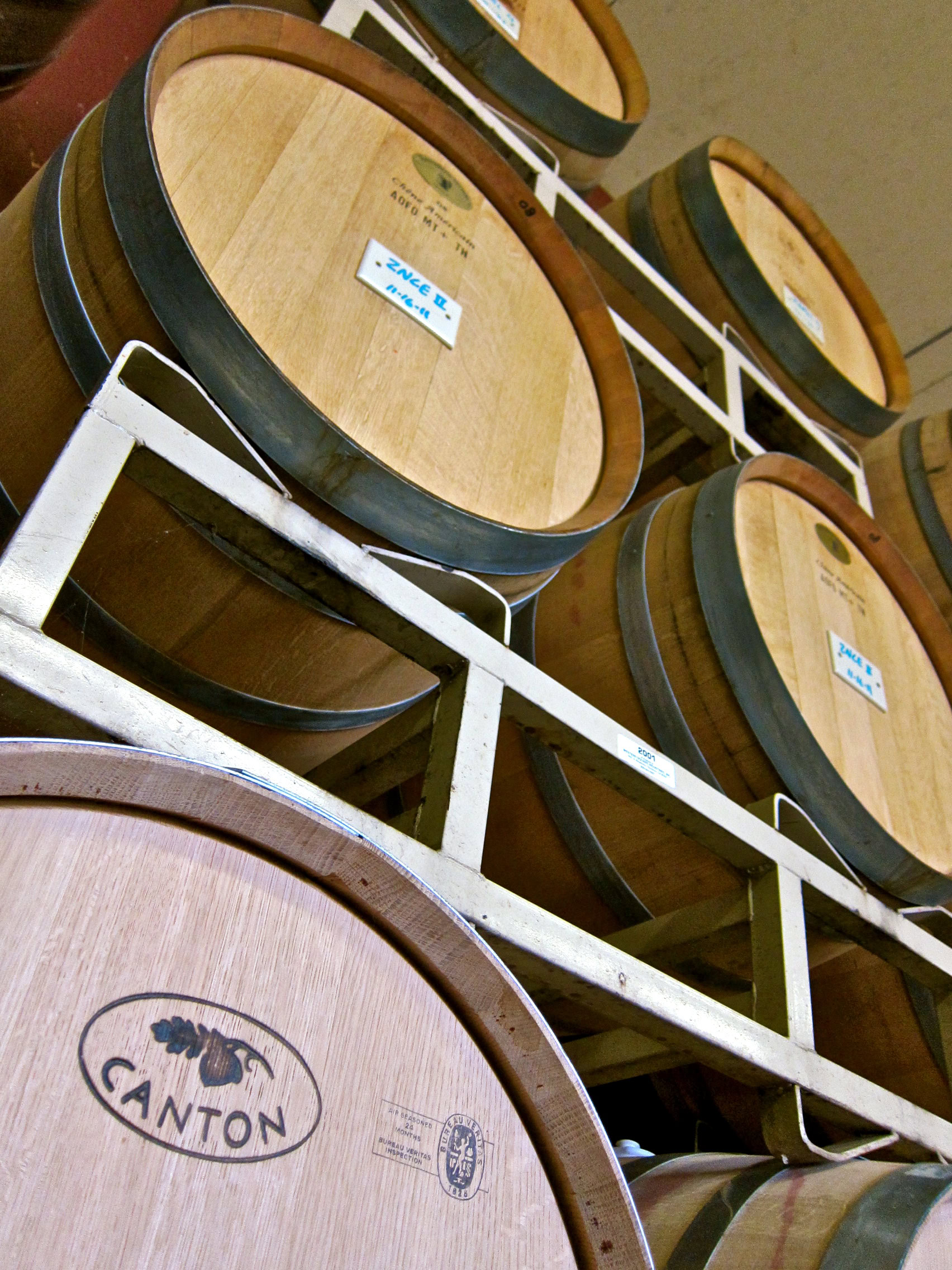 Wine barrels stored on racks at Lodi Winegrape Commission for aging and fermentation.