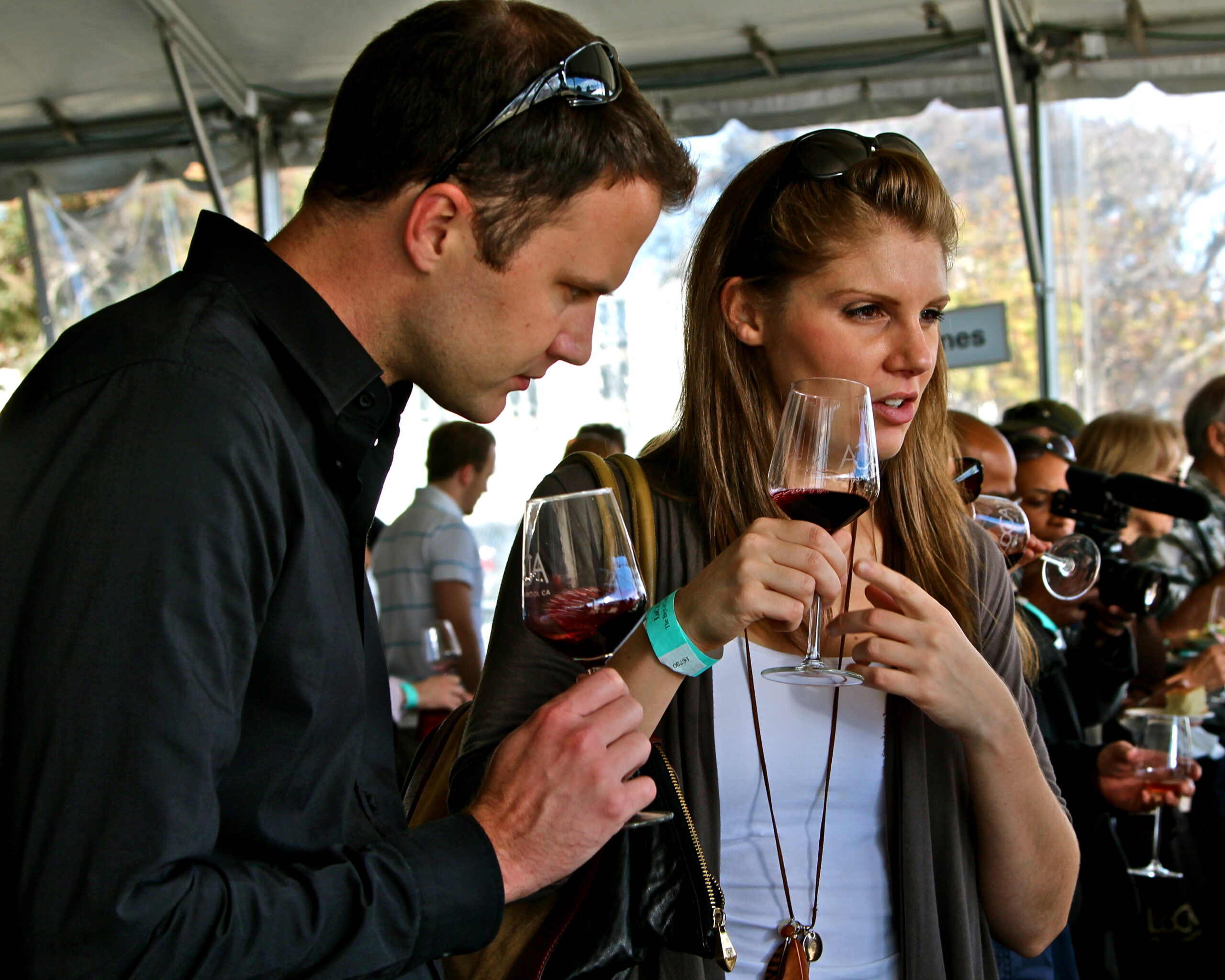 People tasting red wine at a wine event, showcasing Lodi Winegrape Commission's wine offerings.