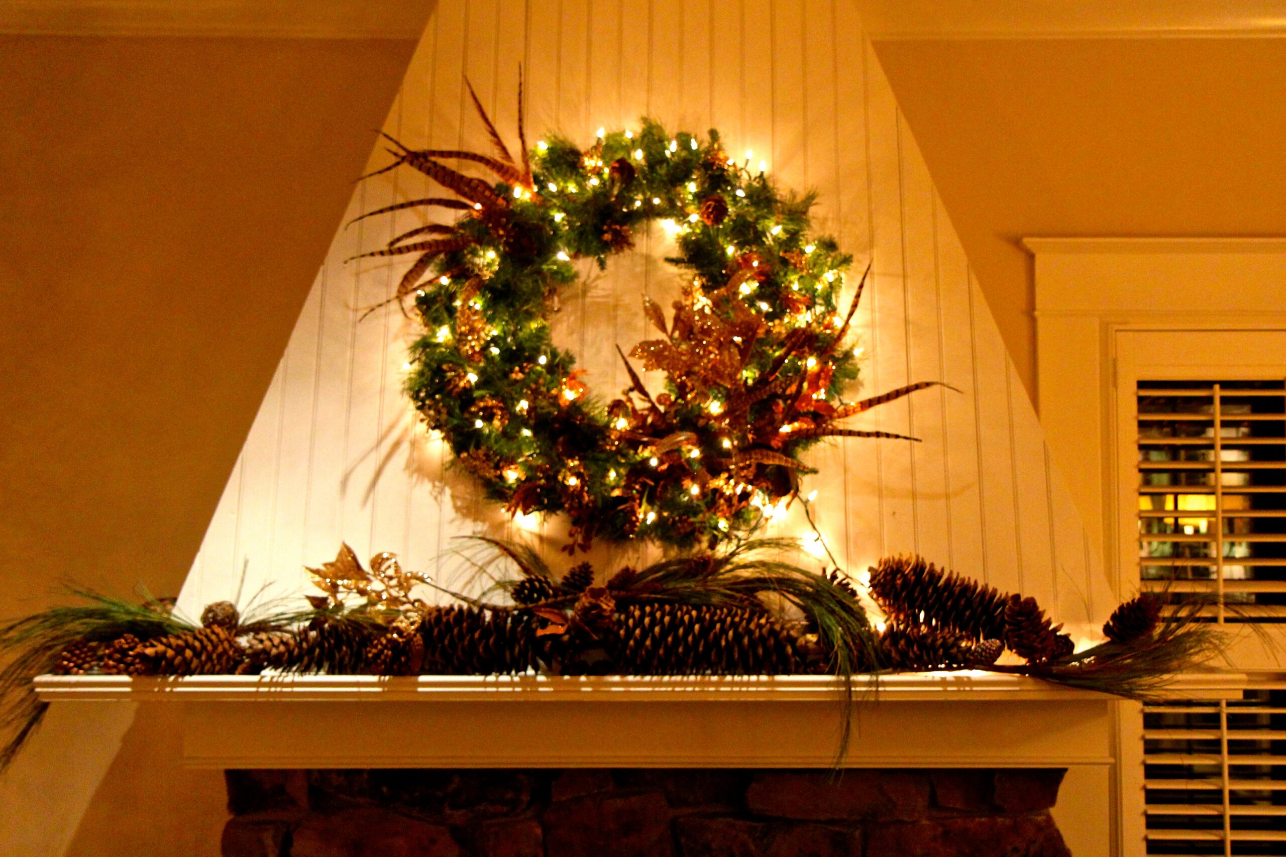 Festive holiday wreath with pinecones and lights on a fireplace mantel in Lodi, California.