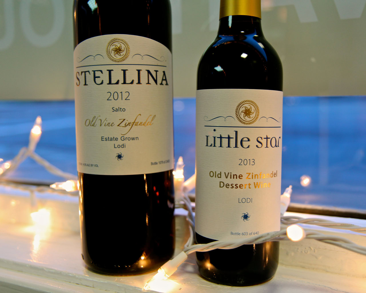Two bottles of Lodi wine from the Lodi Winegrape Commission, Stella 2012 and Little Star 2013, on a festive background.