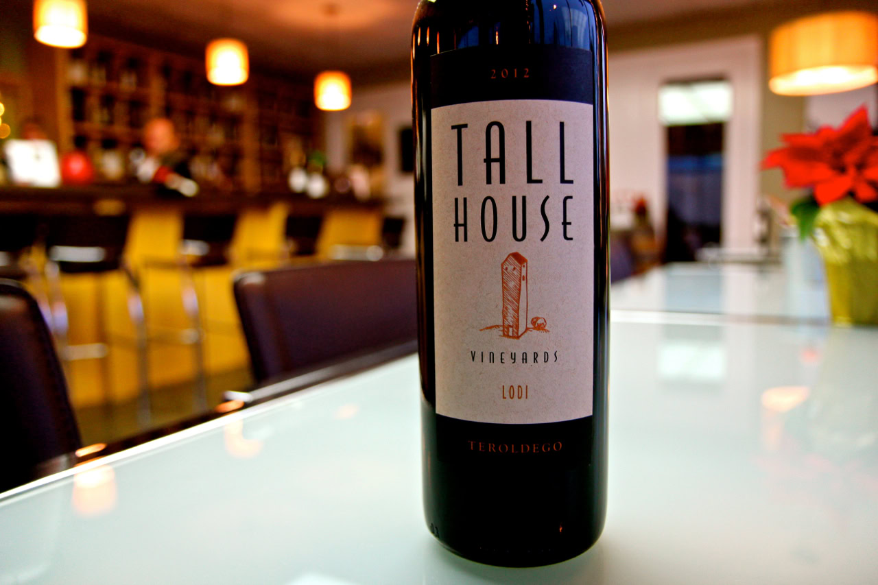 Bottle of Tall House wine from Lodi Winegrape Commission on a bar counter.