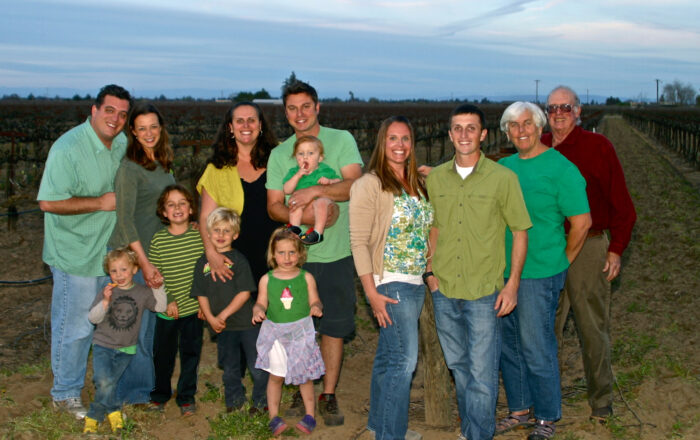 Family enjoying a day at a Lodi vineyard with grapevines in the background.