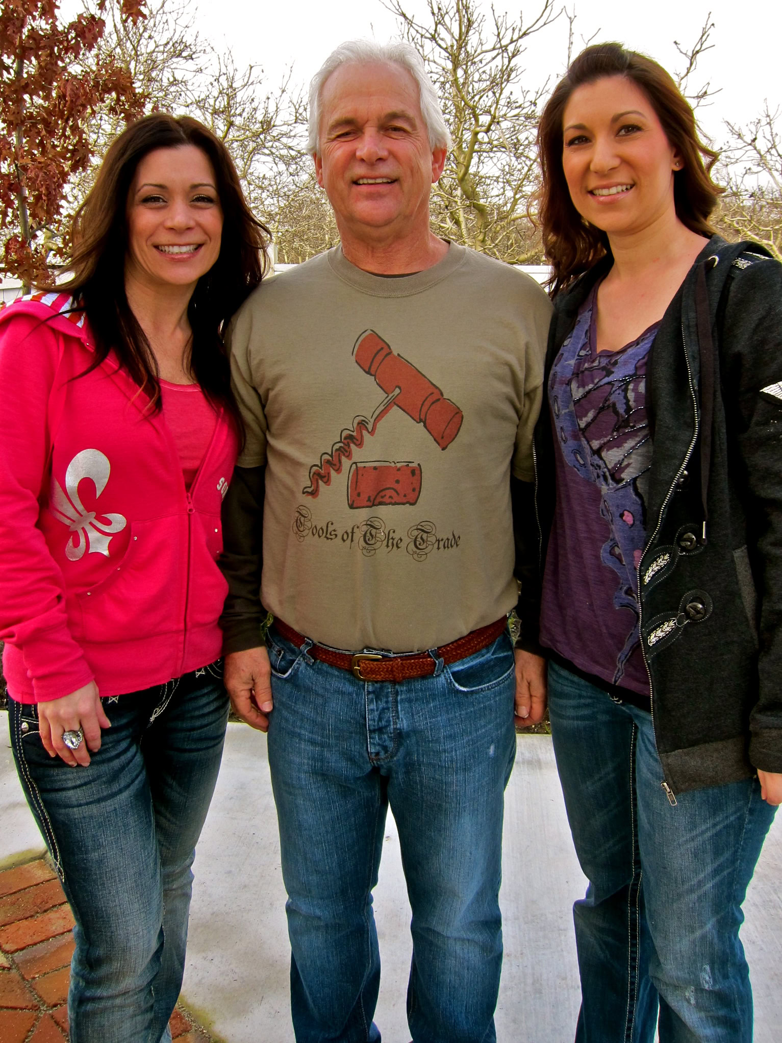 Three people smiling outdoors, representing Lodi Winegrape Commission and local wine industry.