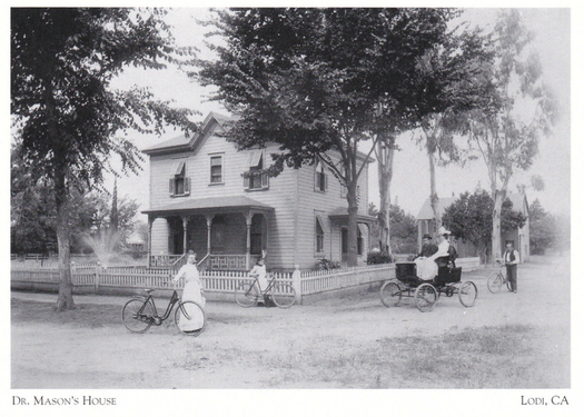 Black and white photo of Dr. Mason's House in Lodi, California, with people and bicycles in front.