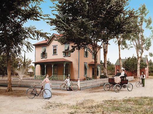 Vintage scene with a historic house, horse-drawn carriage, and people in period clothing in a park setting.