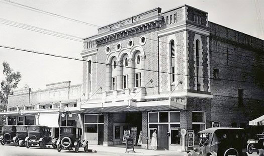 Black and white photo of the historic Lodi Winegrape Commission building with vintage cars parked outside.