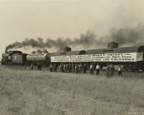 Vintage black and white photo of a historic train with a banner promoting Lodi wine history.