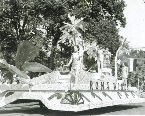 Vintage parade float with palm trees and people, promoting Lodi Winegrape Commission, in black and white.