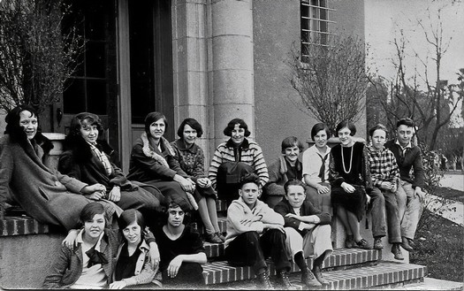 Black and white photo of a group of young people sitting and standing outside a building at Lodi Winegrape Commission event.