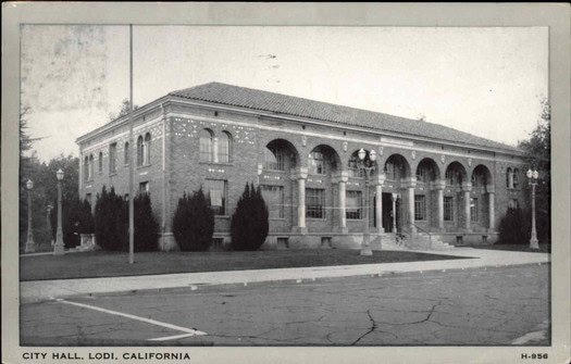 Historic black and white photo of Lodi City Hall in California with arched windows and brick facade.