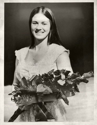 Black and white photo of a smiling woman holding a bouquet of flowers for Lodi Winegrape Commission.