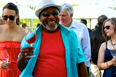 Smiling man enjoying wine at Lodi Winegrape Commission event with friends.