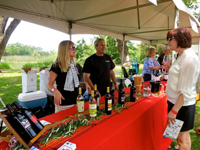 Lodi Winegrape Commission booth at outdoor wine tasting event with staff and visitors.