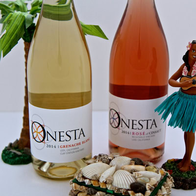 Two bottles of Lodi wine from the Lodi Winegrape Commission, one white and one rosé, with tropical decorations.