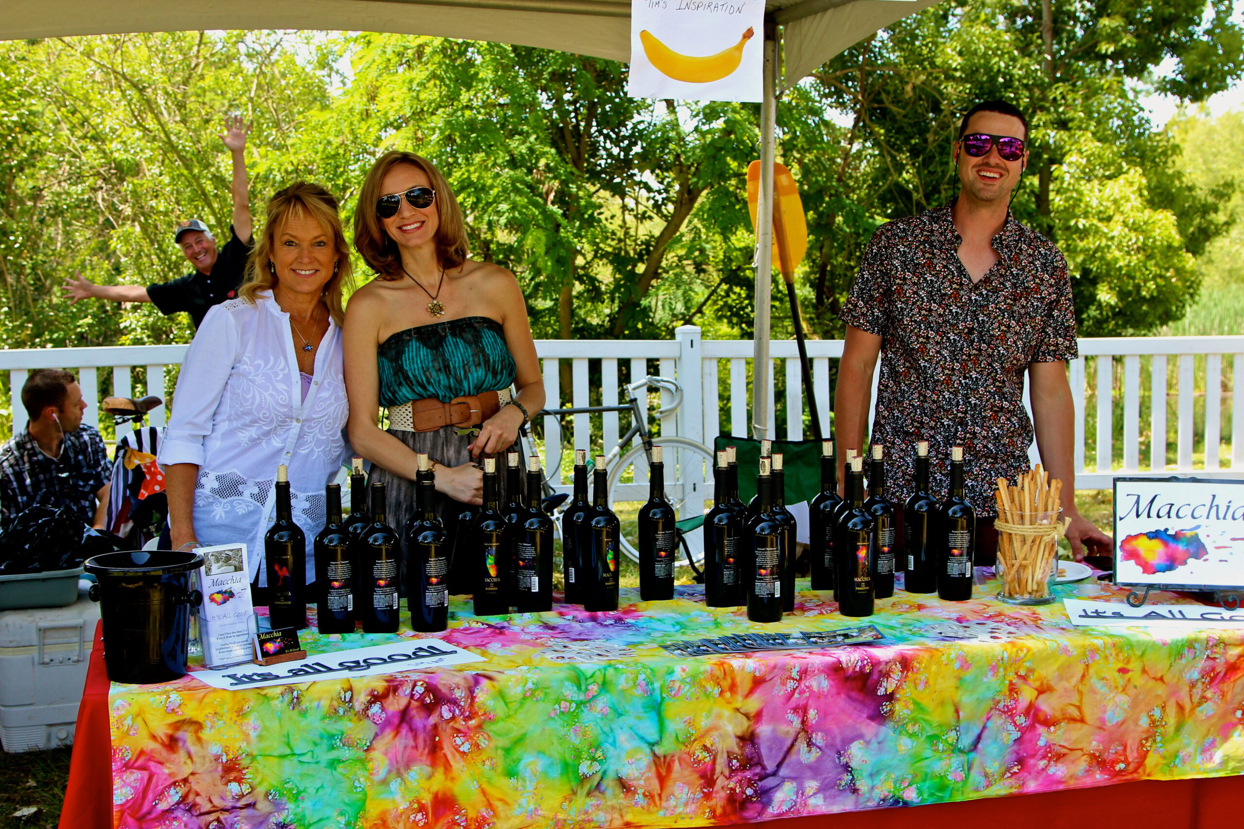 Lodi Winegrape Commission booth with wine bottles and colorful tablecloth at outdoor event.