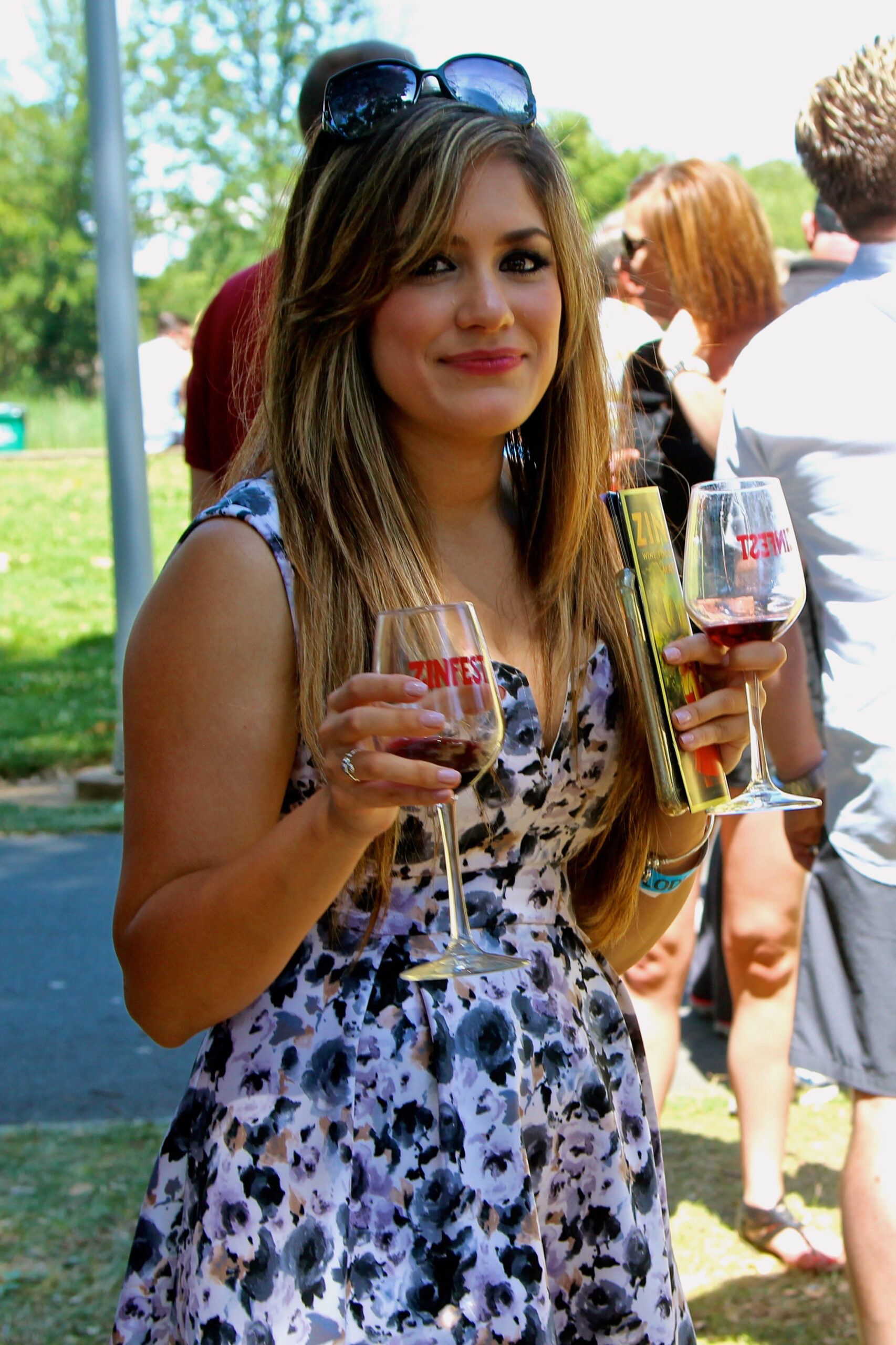 Young woman enjoying wine at Lodi Winegrape Commission outdoor event.