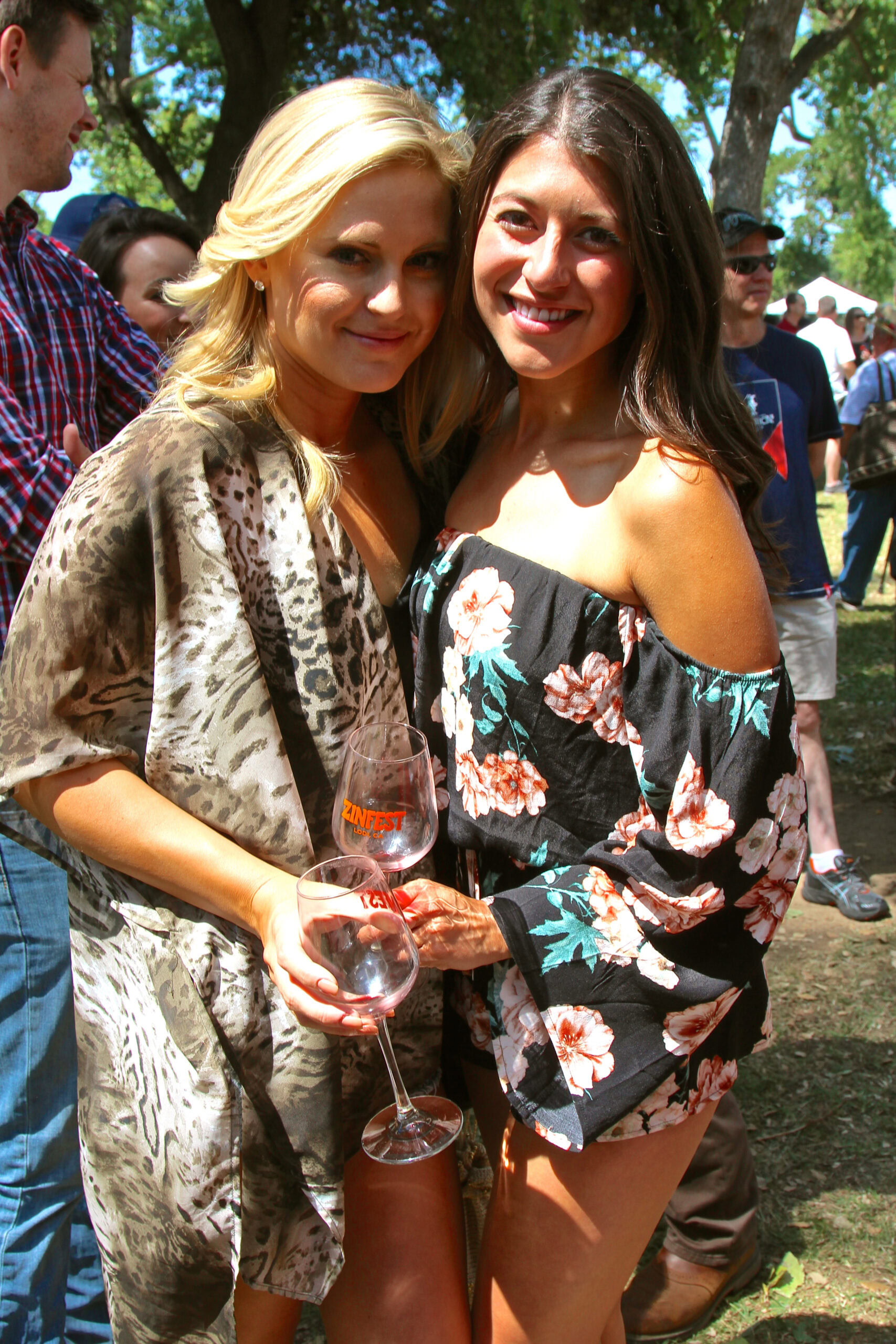 Two women enjoying a wine tasting at a Lodi Winegrape Commission event outdoors.