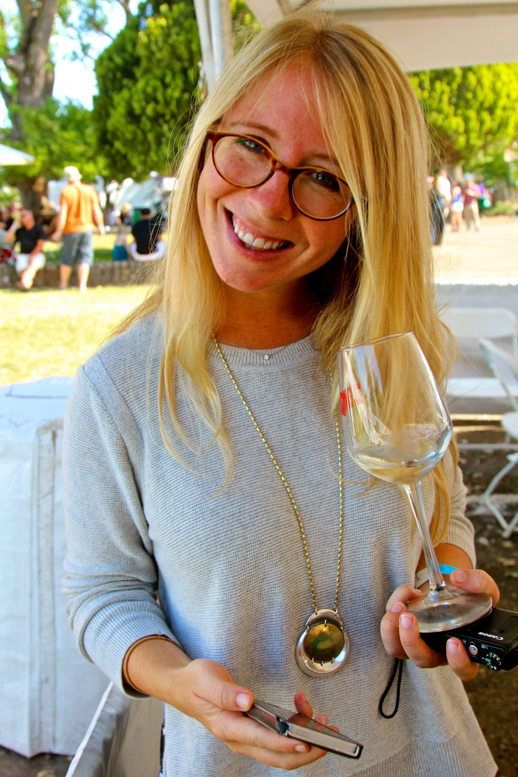 Smiling woman with glasses holding a wine glass at Lodi Winegrape Commission event.
