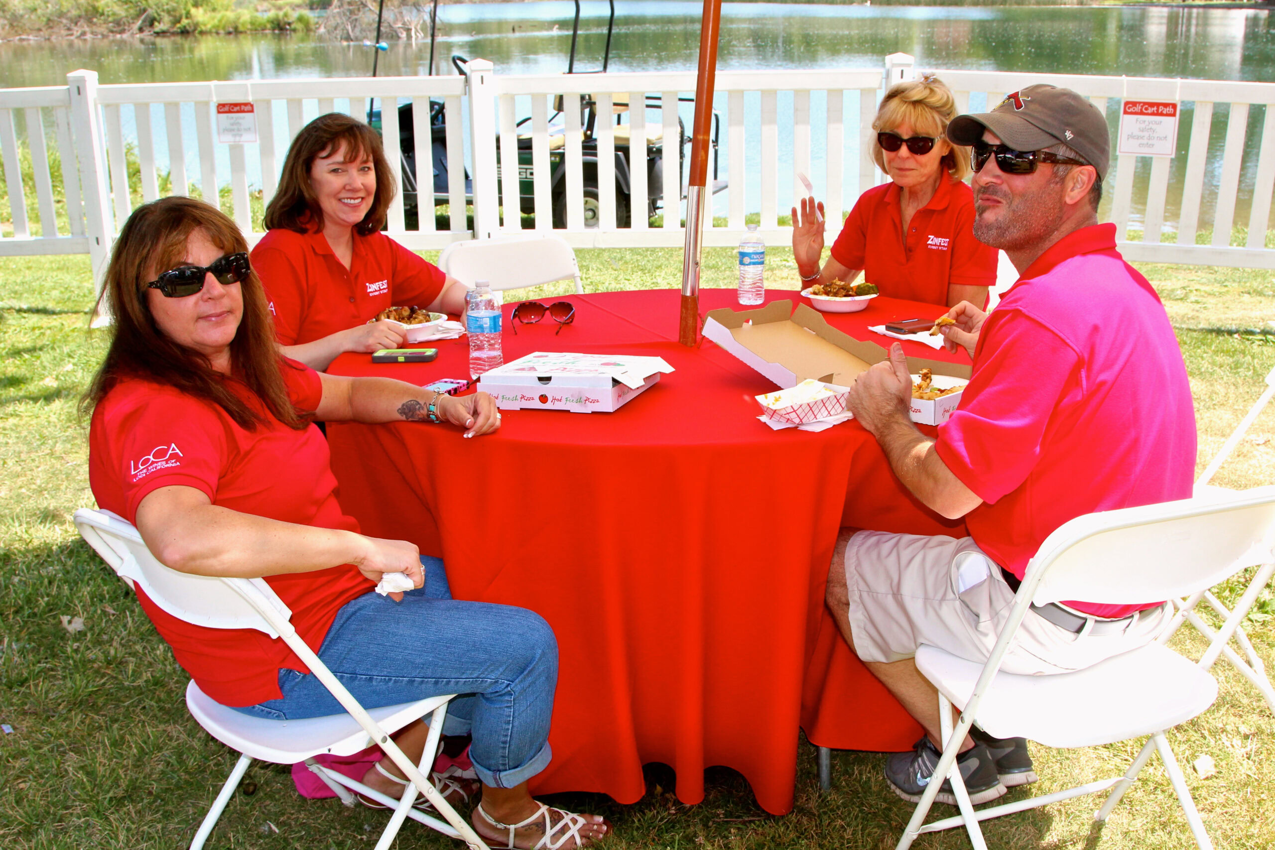 Group of four people enjoying a meal outdoors at a Lodi Winegrape Commission event.