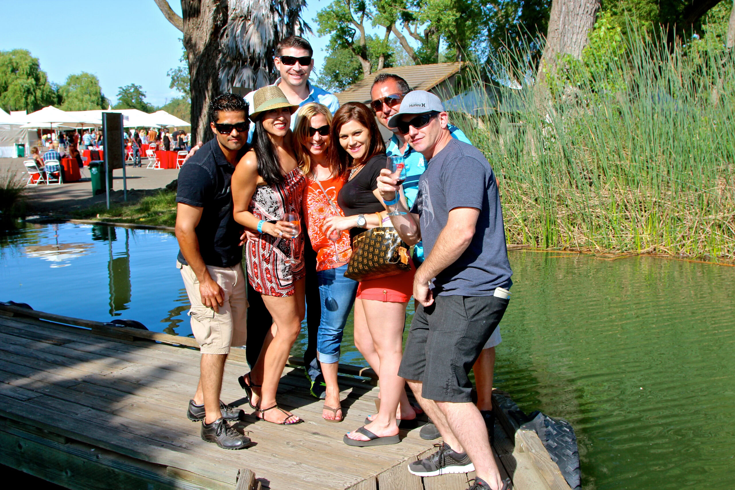 Group of people enjoying a day at the Lodi Winegrape Commission event by the water.