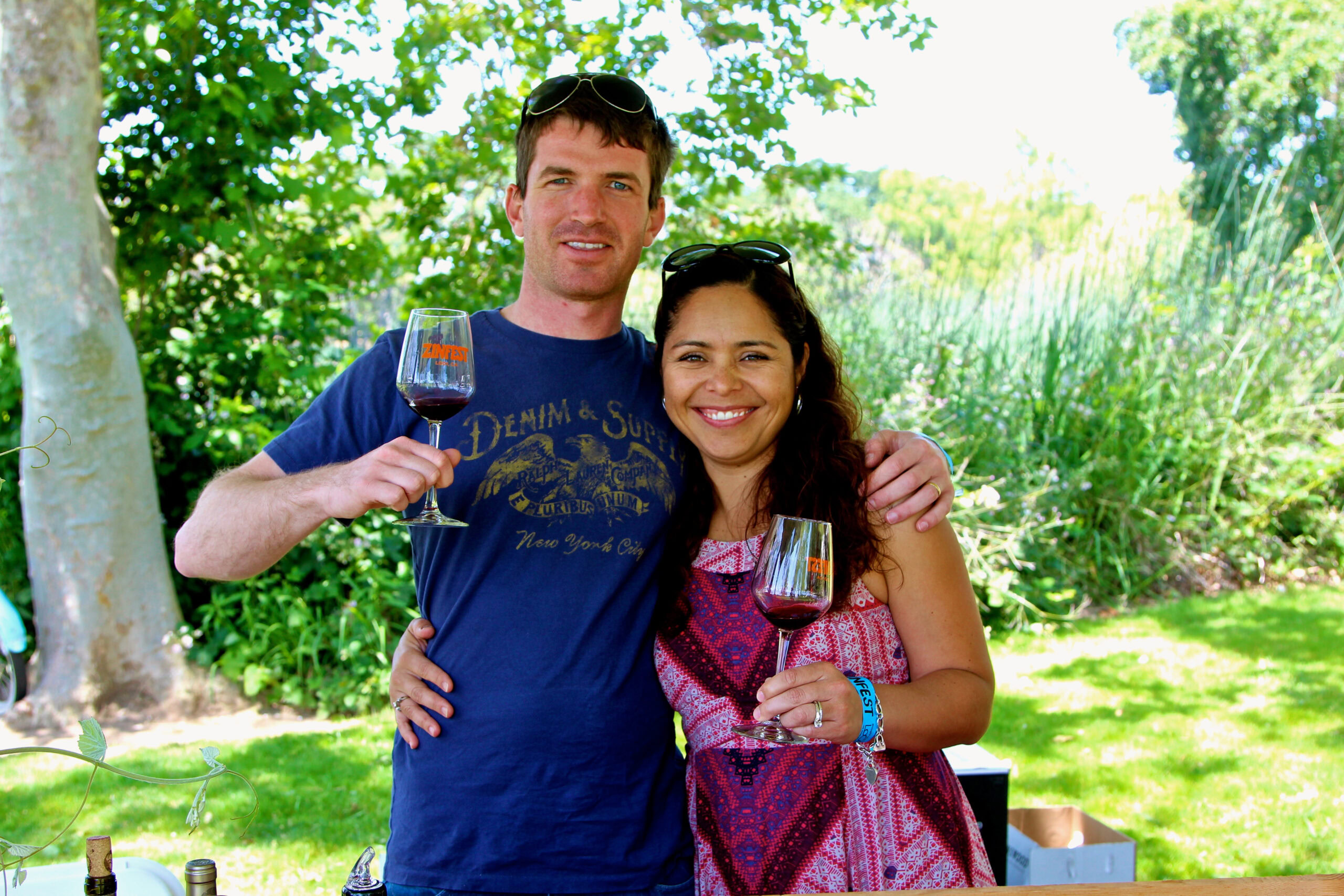 Smiling couple enjoying wine tasting outdoors at Lodi Winegrape Commission event.