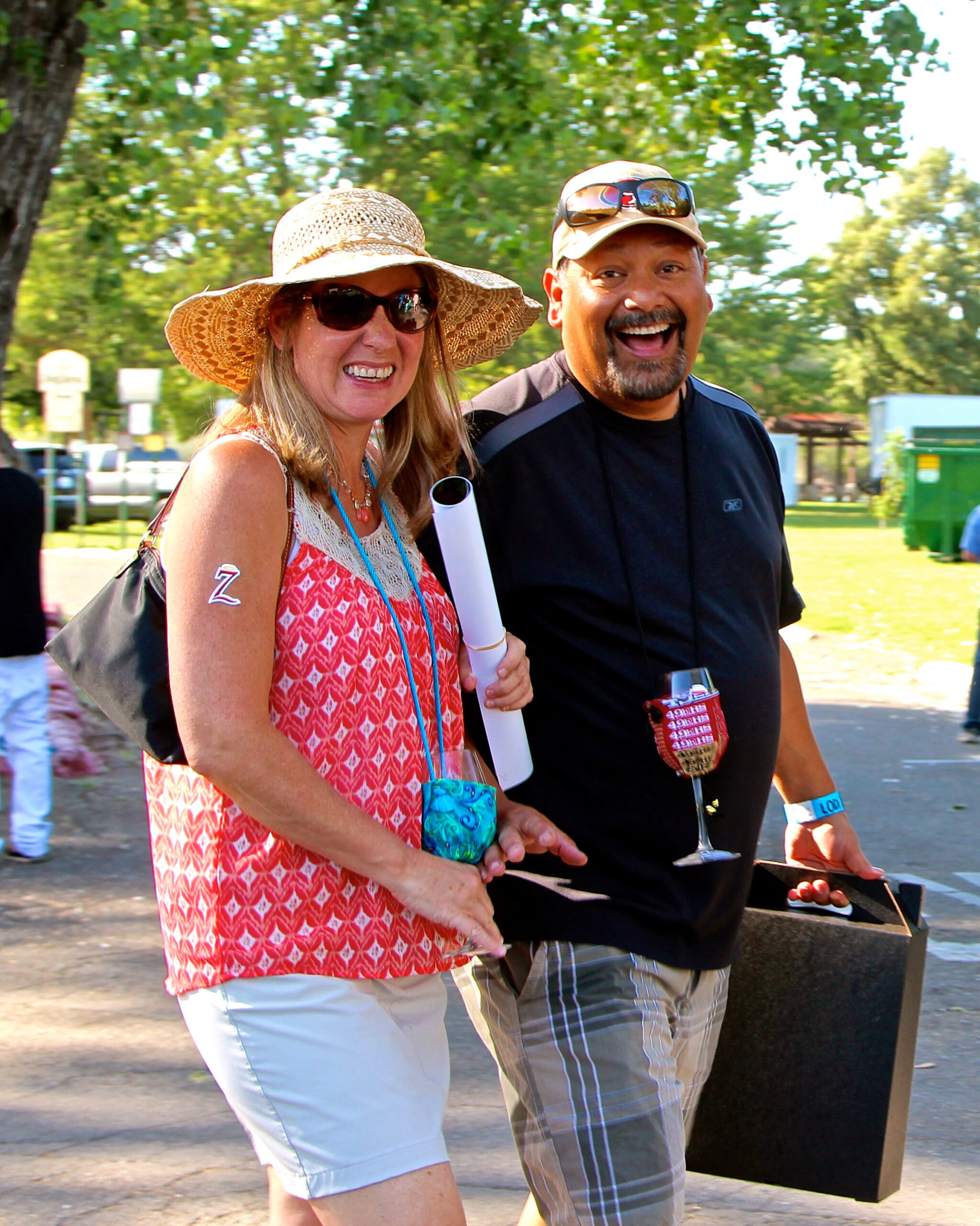 Smiling woman and man at Lodi Winegrape Commission event outdoors, enjoying wine and conversation.