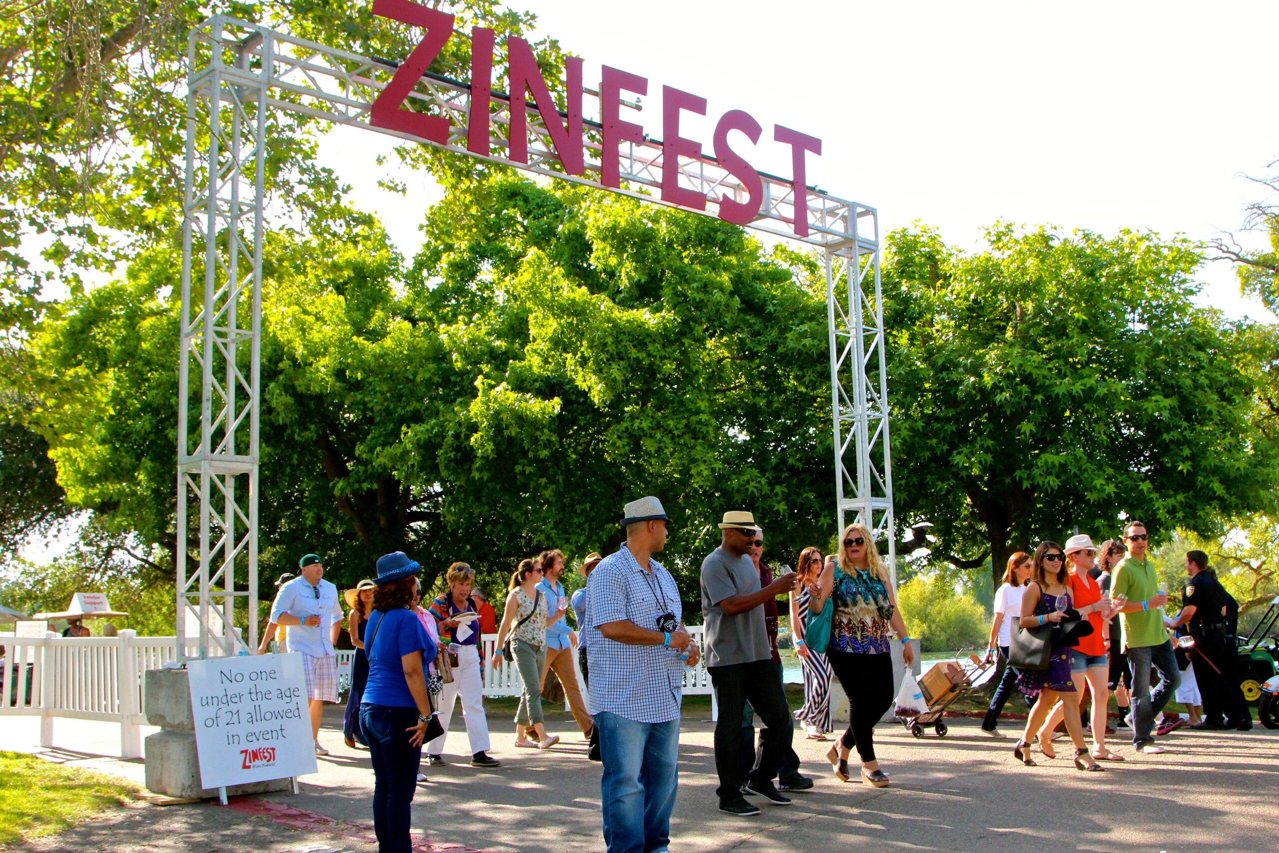 People attending Zinfest event organized by Lodi Winegrape Commission outdoors on a sunny day.